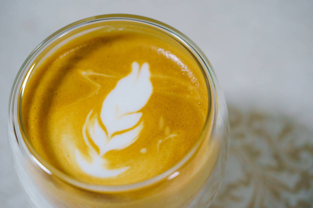 Café caliente latte arte compañero de casa y espuma de leche capuchino perfecto en una taza blanca sobre fondo blanco. Close up y Macro fotografía. - Foto, Imagen