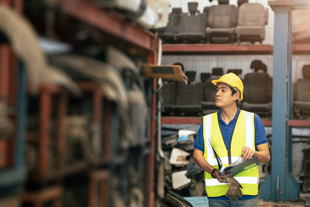 Ασιάτης εργάτης που εργάζεται για τον έλεγχο αποθεμάτων προϊόντων στο ράφι αποθήκης - Φωτογραφία, εικόνα