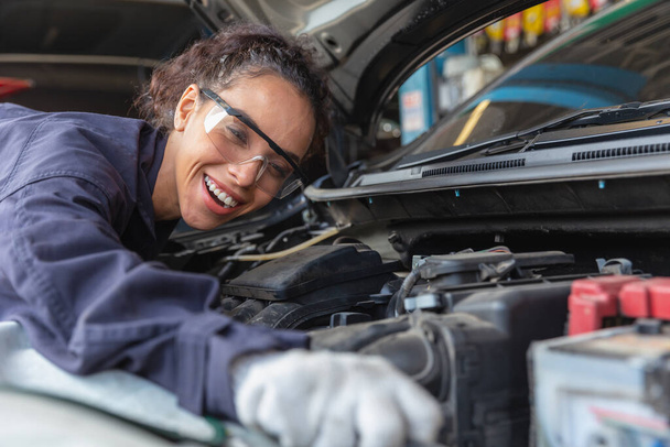 Otomobil tamirhanesinde kadın tamirci, garaj teknisyeni müşteri arabasında tamirci, motor yağı değişimi altında araba teftişi. - Fotoğraf, Görsel