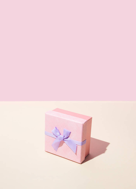 Pink gift box with velvet bow. Pastel background. - Foto, afbeelding