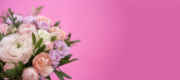 コピースペース付きピンクの背景バナーに手に混合花の花束 - 写真・画像
