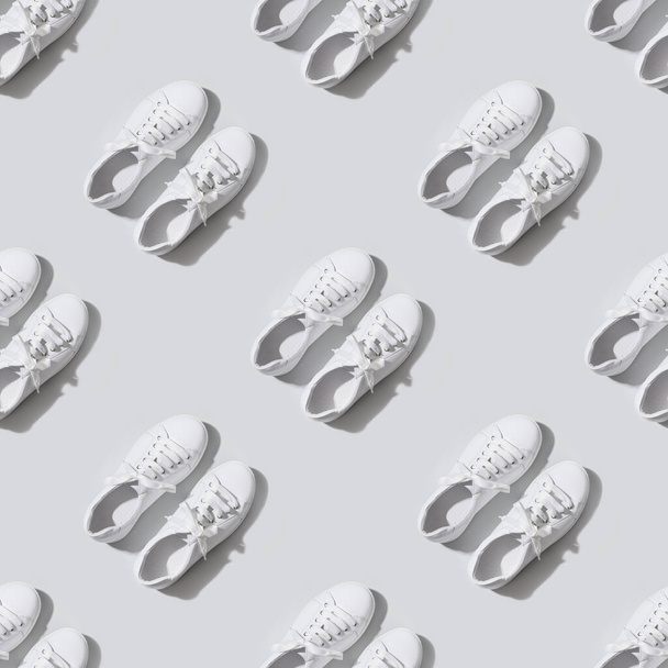 Seamless pattern of white female new gumshoes on grey background. Casual outfit. - Фото, изображение