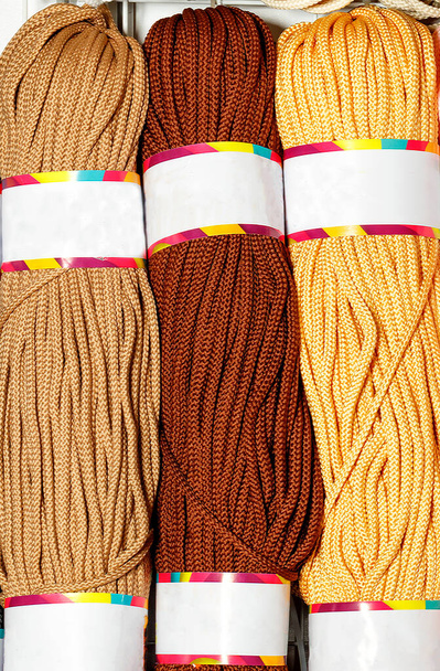 Rouleaux de corde de polyester en différentes couleurs de tons marron et beige, laminés. Image verticale, gros plan, espace de copie. - Photo, image