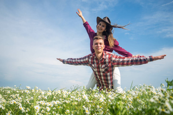 happy couple in love of man and woman in summer chamomile flower field, having fun - Foto, Imagen