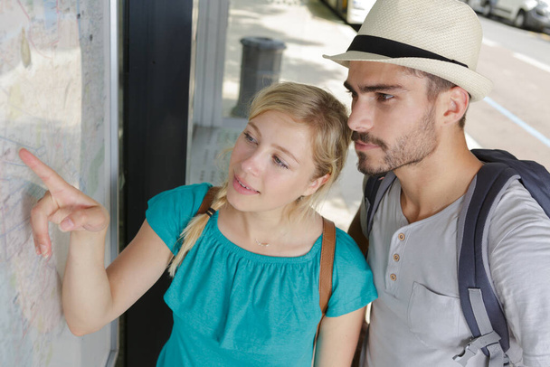 young tourist couple looking at a map - Photo, image