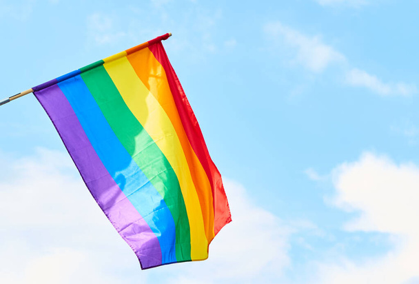 LGBT flag against blue sky with clouds - 写真・画像