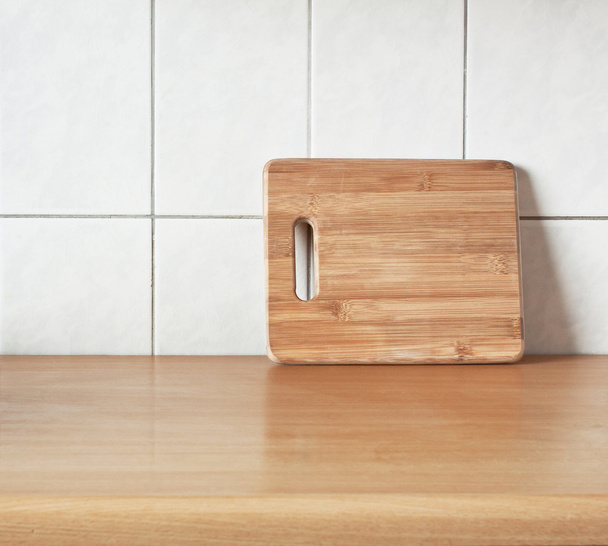Tabla de bambú de corte marrón para cocinar en la mesa
 - Foto, imagen