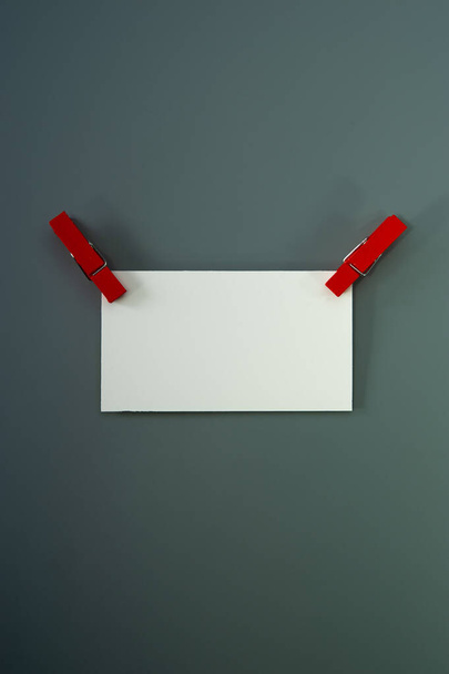 one blank business card and clothespins lie on a gray background. Cover. - Photo, Image