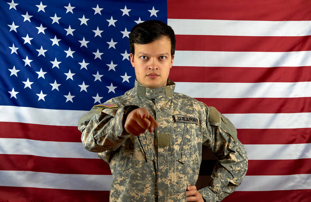 American army soldier points his finger to you. American soldier on the background of the national flag. US army. The concept of conscription. - Fotó, kép