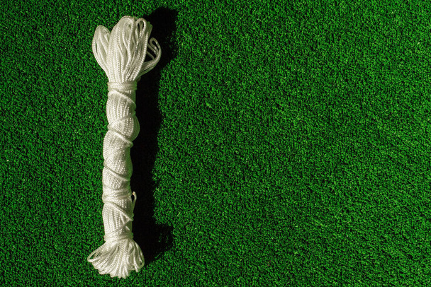 fabbrica corda di nylon su erba artificiale verde. Corda di corda in una matassa. corda skein sfondo. - Foto, immagini