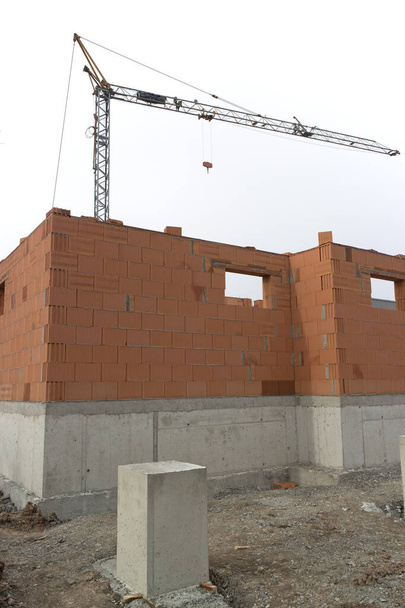 Maison chantier de construction avec murs de briques et une grue de construction - Photo, image