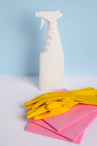 Bottle spray stain remover with rag and rubber gloves. General or regular cleanup. Empty place for text or logo. isolated on blue background. High quality photo - Fotoğraf, Görsel