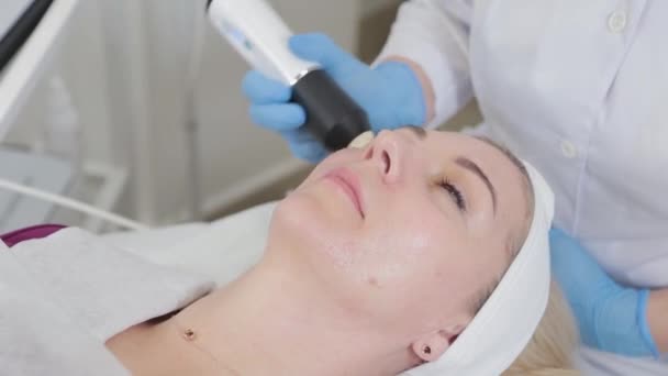 Esteticista profissional mulher fazendo máquina de carboxiterapia no rosto de um cliente. - Filmagem, Vídeo