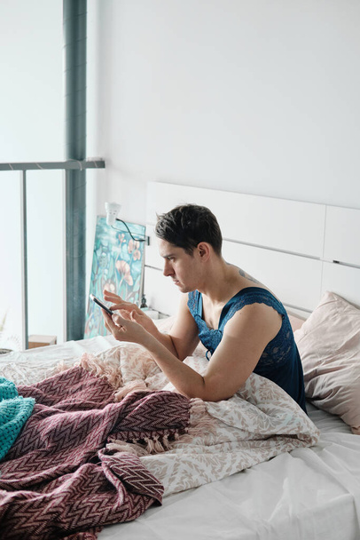 Man using phone in the bed - Фото, изображение