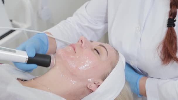 Επαγγελματική αισθητικός γυναίκα κάνει μασάζ προσώπου με συσκευή καρβοξυθεραπείας στο σαλόνι ομορφιάς. - Πλάνα, βίντεο