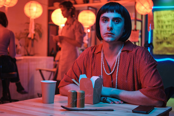 Transgender siedzi przy stole w barze - Zdjęcie, obraz