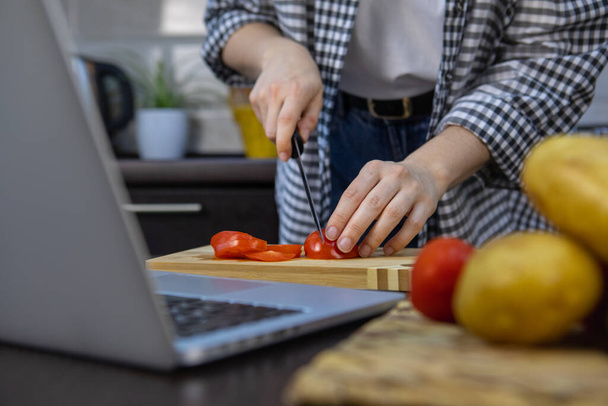 Kadın domatesleri panoda kesiyor mutfak fotokopi alanı yumuşak odak - Fotoğraf, Görsel