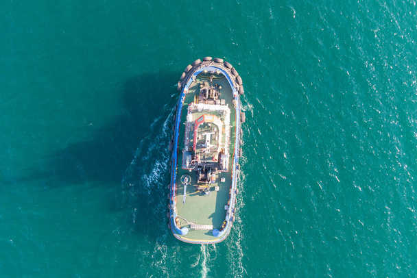 Морський буксир рухається від портової водної зони до відкритого моря. Фото з вертольота. Вид зверху
 - Фото, зображення