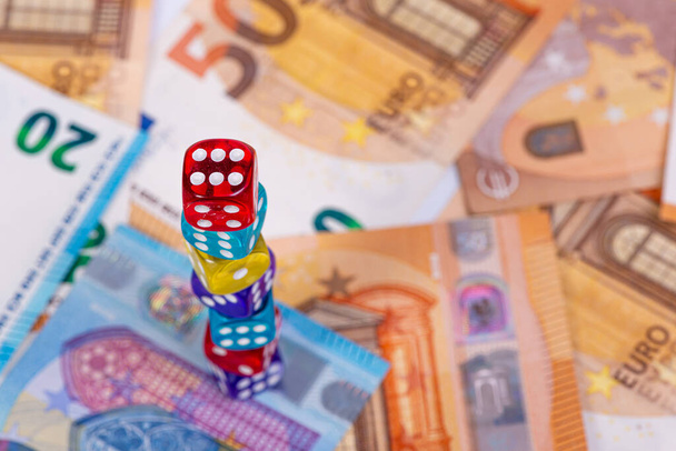 pyramid of dice on the background of euro banknotes, business risk and opportunity concept, top view - 写真・画像