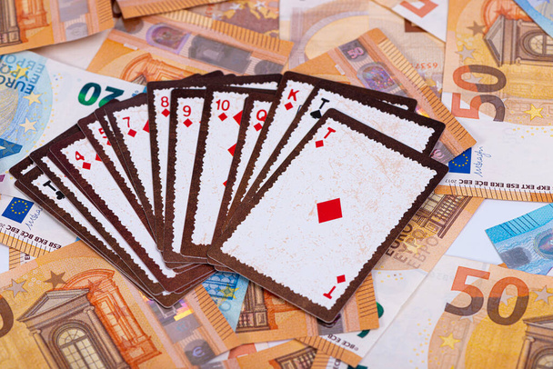 ユーロ紙幣やギャンブルの概念を背景にトランプをしたり - 写真・画像
