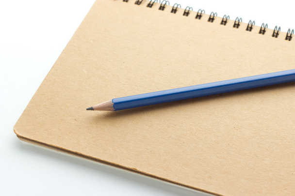 Cuaderno y lápiz aislados en blanco
 - Foto, imagen