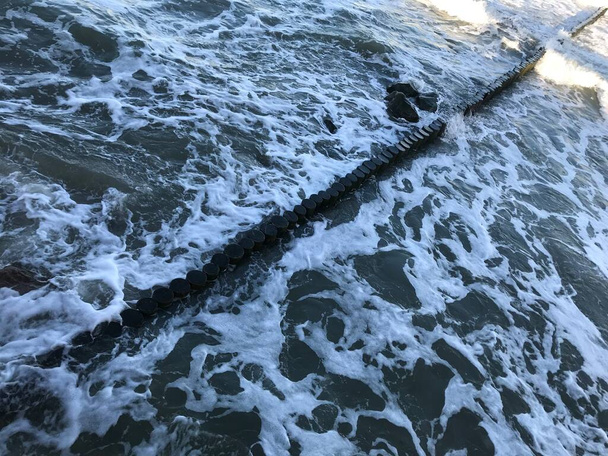 Briser les vagues sur un brise-lames en bois sur la côte de la mer Baltique. - Photo, image