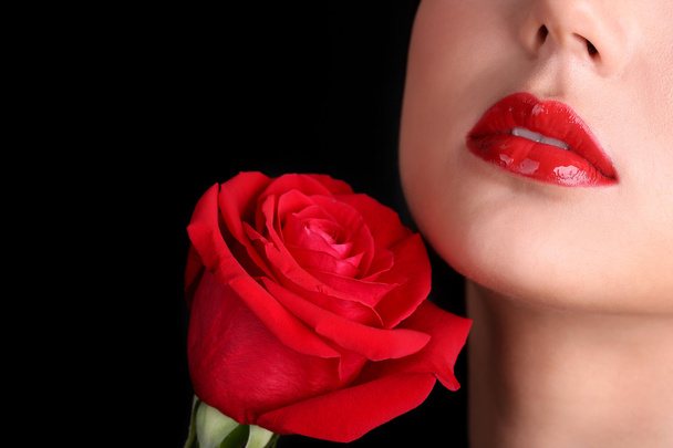 Girl with red lips and rose on dark background - Zdjęcie, obraz