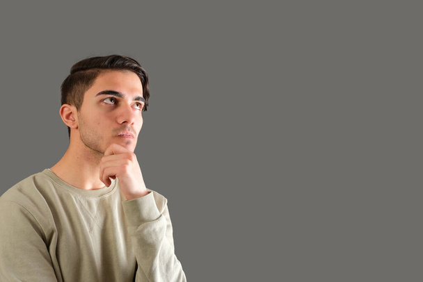 Retrato de hombre joven reflexivo aislado sobre fondo gris - Foto, Imagen