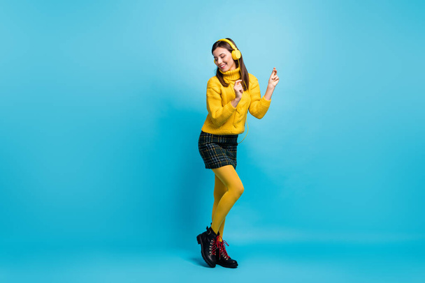Full length photo of shiny charming young lady wear yellow sweater headphones dancing rhythm isolated blue color background - Foto, immagini