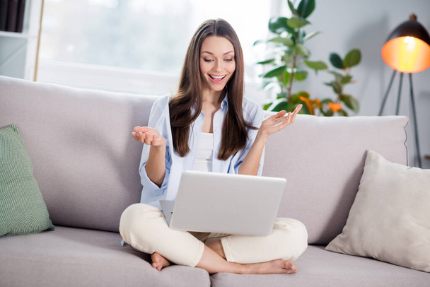 Full size photo of nice optimistic brunette long hairdo lady sit talk laptop on coach wear blue shirt at home - Photo, image