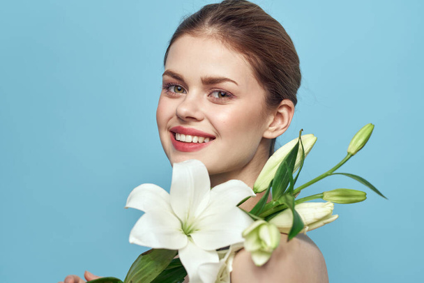 Kobieta z białymi kwiatami na niebieskim tle  - Zdjęcie, obraz