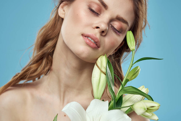 Žena s kyticí bílých květin na modrém pozadí - Fotografie, Obrázek