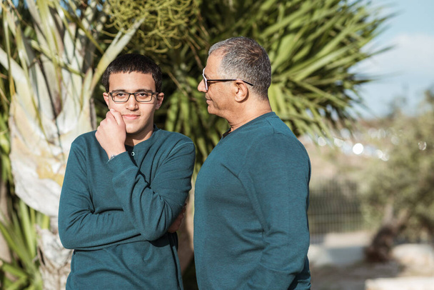 Teenager geht mit Vater im Park spazieren. - Foto, Bild