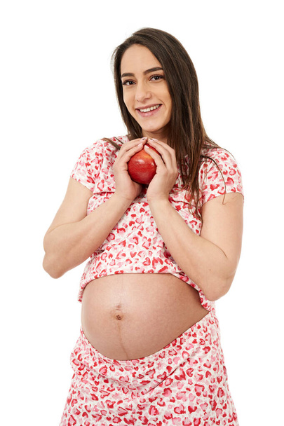 Pregnant woman with a juicy red apple, having cravings - 写真・画像