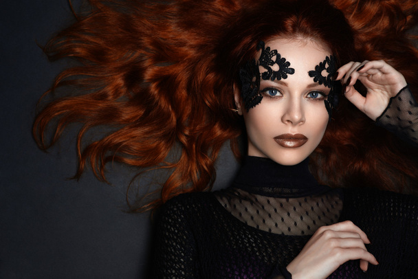 beautiful red-haired girl lace makeup in the dark - Photo, Image