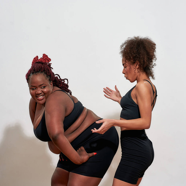 Woman with extra size twerks in front of smaller one - Foto, immagini