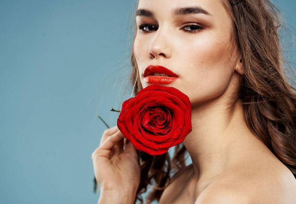 Сексуальна жінка з опушеними плечима тримає троянду. Високоякісна фотографія
 - Фото, зображення
