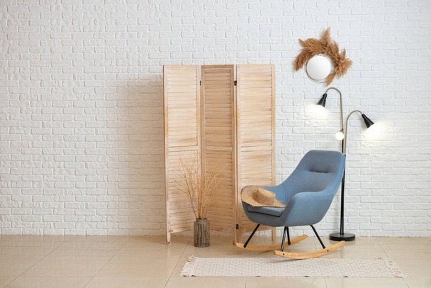 Удобное кресло и складной экран в интерьере современной гостиной - Фото, изображение