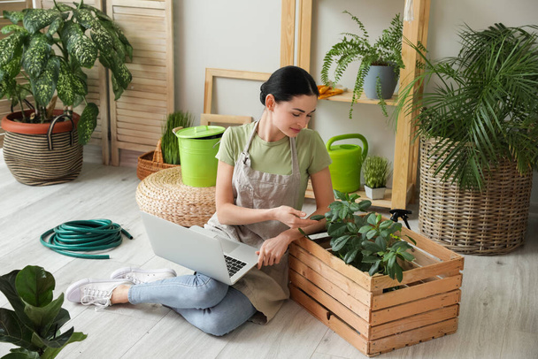 Joven jardinero femenino con portátil en casa - Foto, imagen