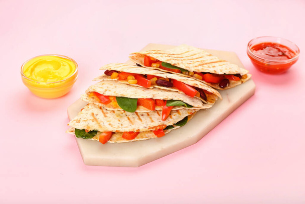 Tablero con sabrosas quesadillas vegetarianas y salsas sobre fondo de color - Foto, Imagen