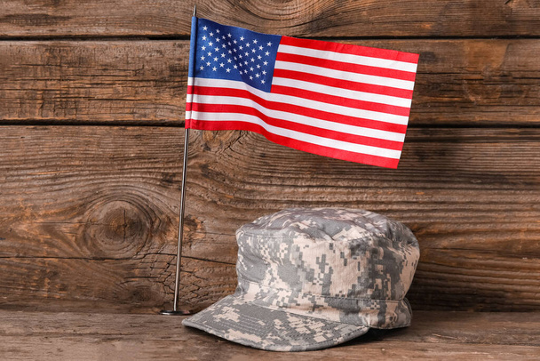 Tahta arka planda Amerikan bayrağı olan askeri şapka. - Fotoğraf, Görsel