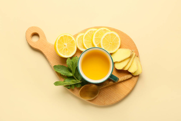 Cup of tea with ginger, mint and lemon on color background - Фото, изображение