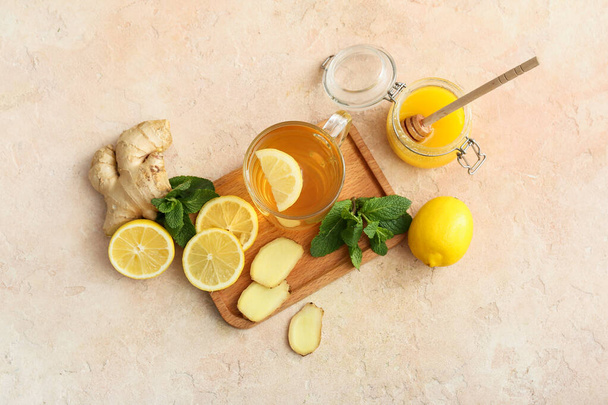 Taza de té con jengibre, miel y limón sobre fondo de color - Foto, imagen