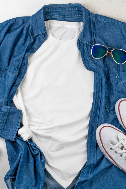 White T-shirt with place for text. Blue denim shirt, sneakers, glasses - a set of clothes for walking. T-shirt mockup for printing. Stylish kit. Copy space. - Foto, Imagen