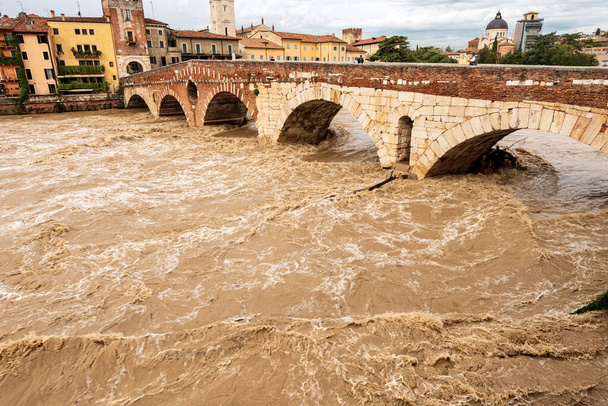 Verona, Ponte Pietra (Puente de piedra), siglo I a.C., y el río Adigio en inundación después de varias tormentas violentas. Patrimonio de la Humanidad, Véneto, Italia, Europa. - Foto, Imagen