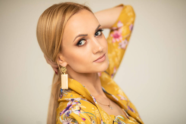 Beautiful blonde Caucasian woman in fashionable earring. - Fotoğraf, Görsel