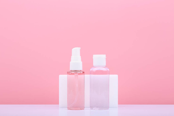 Cleaning gel or foam for face washing and cleansing and exfoliating lotion against pink background with copy space - Valokuva, kuva