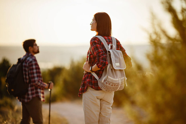 Portrait de jeune couple heureux s'amusant lors de leur voyage de randonnée. Couple de randonneurs caucasiens et asiatiques s'amusant en vacances d'été. Jeunes randonneurs dans la nature. - Photo, image