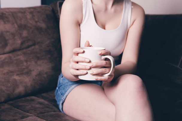 Close-up of female hands with a mug of drink. - Photo, image