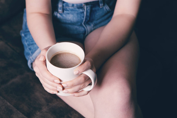 Close-up of female hands with a mug of drink. - Foto, immagini